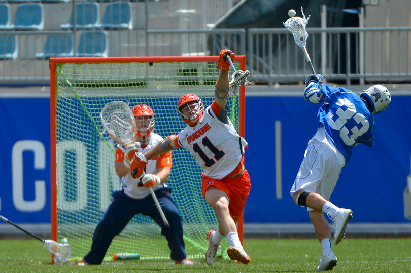 Duke's Justin Guterding fires a shot as SU defender Brandon Mullins contests and goalie Bobby Wardwell awaits.