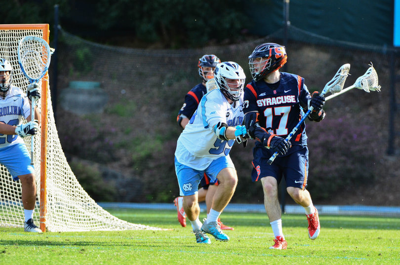Junior attack Dylan Donahue surveys his options while being pressed by Evan Connell.