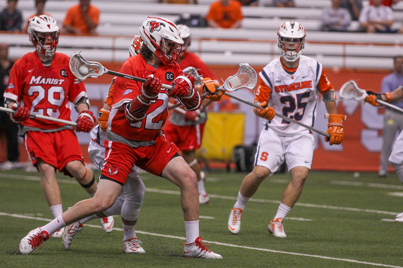 A Marist player tries to rip a shot past the Syracuse defense. 