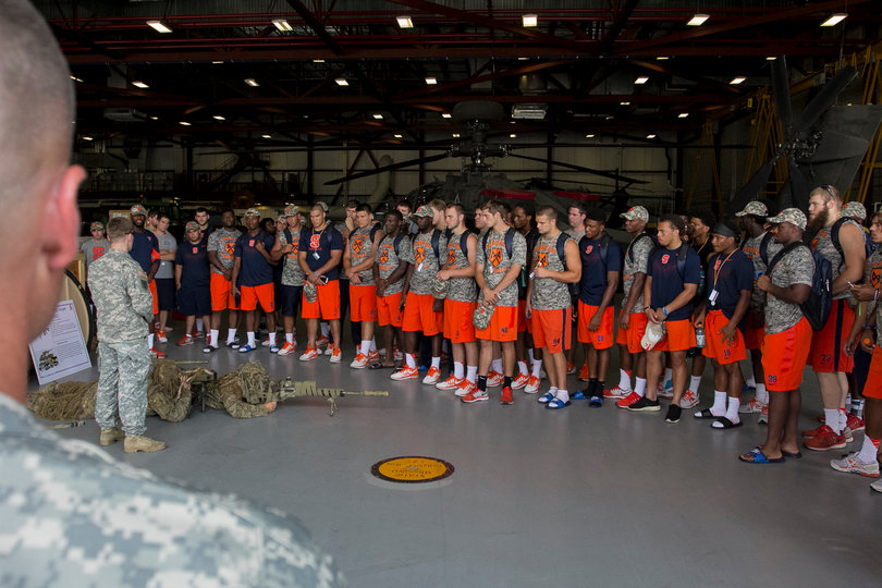 Syracuse players look on while a tour guide shows them around the airfield. Several players used their camera phones to take pictures of the helicopters. 