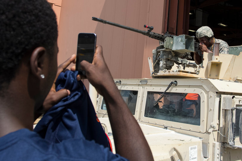 Amir Ealey sits atop a humvee while a teammate takes a photo of him. A lot of the Syracuse players took turns simulating the humvee experience. 