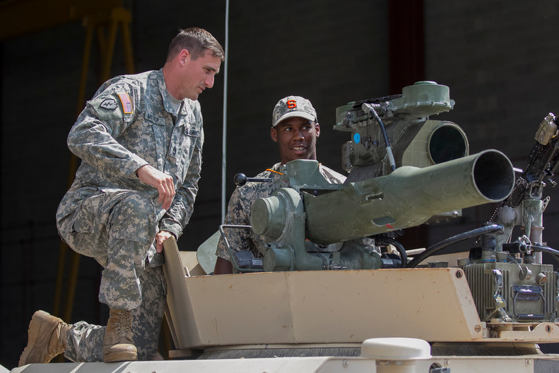 Ealey talks with a service member who was helping to guide Syracuse players through a tour of the airfield. 