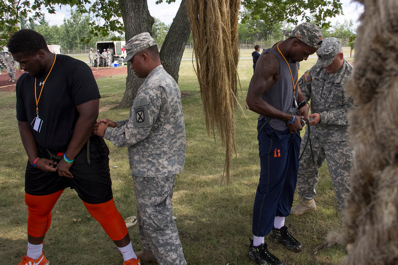 Kayton Samuels (left) and Corey Winfield (right) have their harnesses tightened by soldiers.