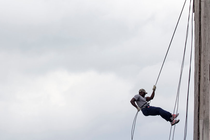 A Syracuse player hangs in mid-air while descending the wall.