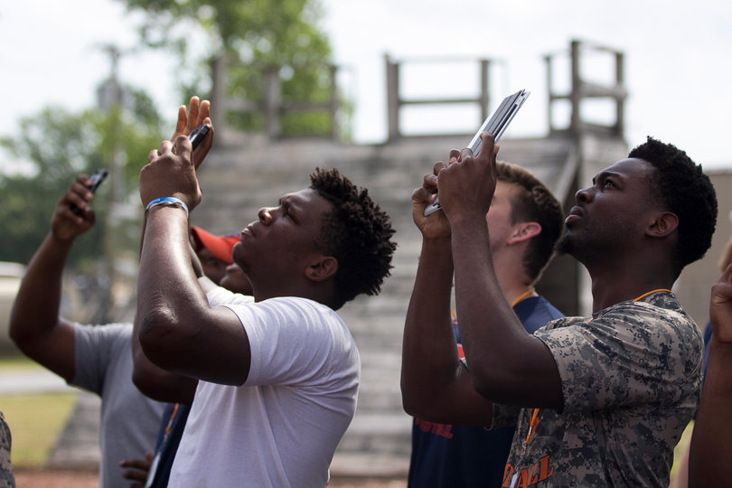 Kenny Carter (left) and Adly Enoicy (right) film a soldier performing a rappelling demonstration.