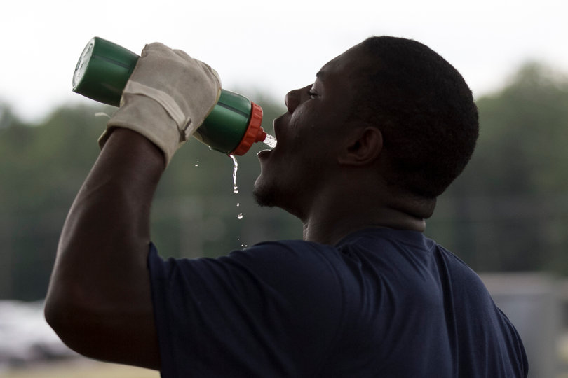 Zaire Franklin drinks from his water bottle while wearing rappelling gloves.
