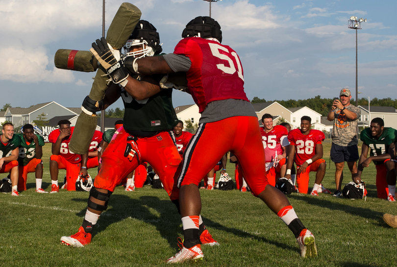 (From left) Senior center Rob defends against a blow from senior defensive end Donnie Simmons.