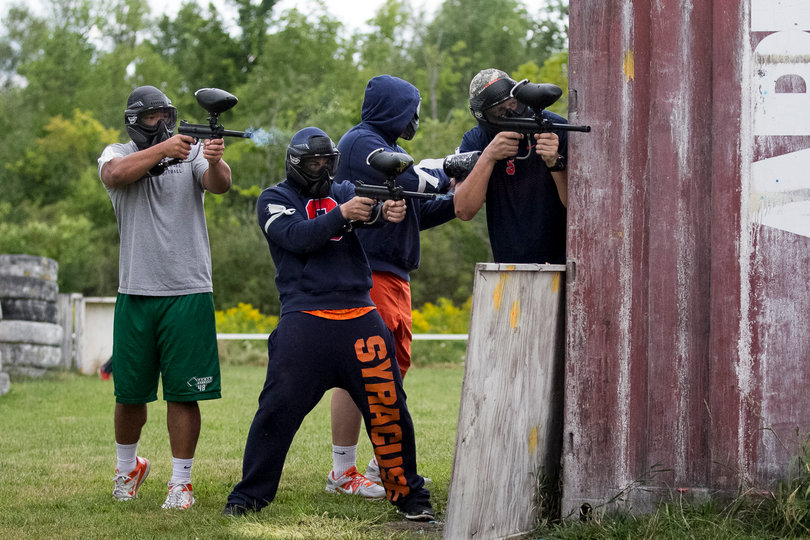 Senior long snapper Keith Mitsuuchi (left) fires from behind a dumpster as teammates line up their shots.