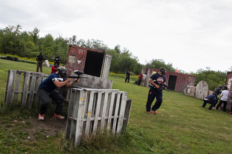 Players hide behind several barriers as one walks by after getting shot.