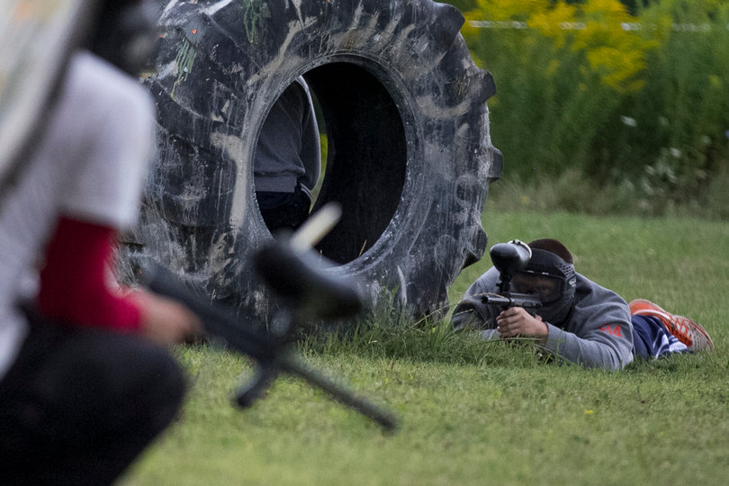 Junior hybrid Ben Lewis hides behind a tire while shooting at his opponents.
