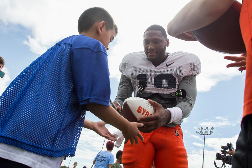 Senior quarterback Terrel Hunt signs an autograph for Antonio Hernandez, 8, of Fort Drum. Hernandez is a tight end for the Fort Drum Mountaineers Pop Warner team.