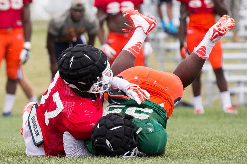 Freshman defensive end Amir Ealy takes Fredericks to the ground during the scrimmage.