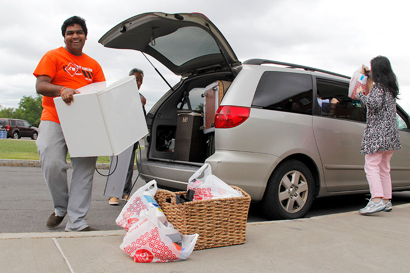 Pruthvi Kilaru, a Goon Squad volunteer, carries a mini fridge for an incoming student on move-in day. 