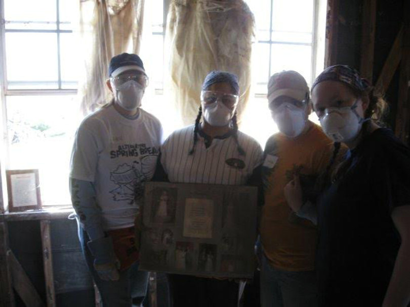 Volunteers Ann Loyek, Valerie Martinez, Jessica Krupski and Greta Kleckner (left to right) found a wedding dress and a wedding album inside a home of a family killed in the hurricane.