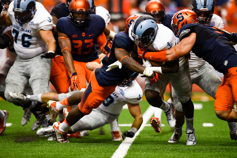 Two SU defenders wrap up a Rhode Island running back trying to advance on the play.