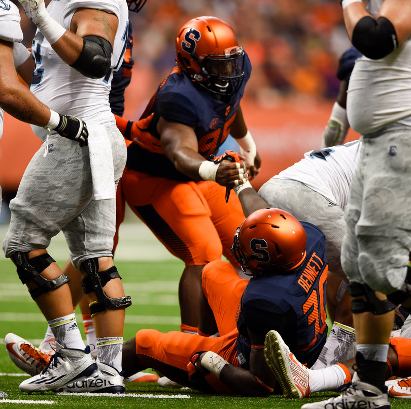 Defensive tackle Chris Slayton helps linebacker Parris Bennett up off the ground.