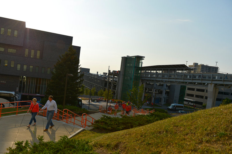 Two individuals walk toward the Carrier Dome before the game. 