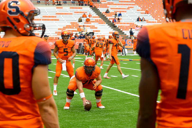 Junior center Jason Emerich simulates snapping the ball to quarterback Austin Wilson before the game.