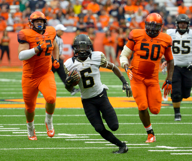 Wake Forest receiver Tabari Hines hauls in a pass on the run, outpacing SU's Steven Clark (left) and John Raymon (right).