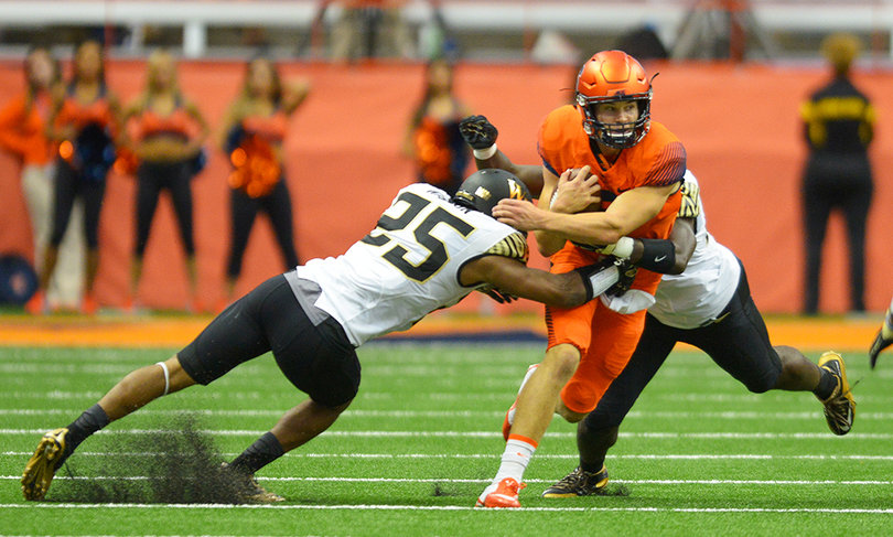 Dungey looks to squeeze through two Wake Forest defenders, including an arm tackle by Brad Watson (25).
