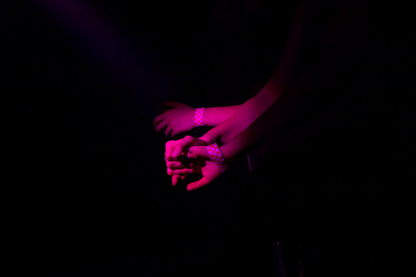 Concert-goers hands entangle during the night of raving. 