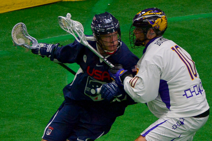The Iroquois' Adam Bomberry defends an American player who is observing the rest of the field.