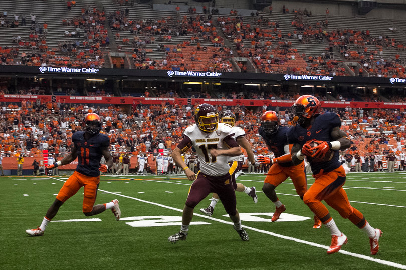 A Syracuse player tries to avoid a tackle as he runs up the field near the 20-yard line. 