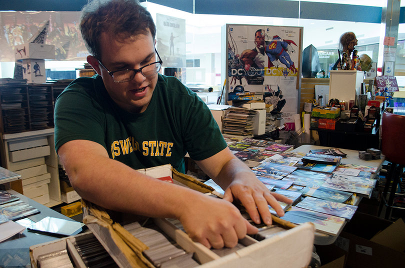 Jake Chapin, the subscription manager, shuffles through a box of Magic: The Gathering cards. There will be a pre-release for the game's new set of cards, The Battle of Zendikar, this weekend at Cloud City.  