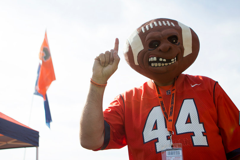 A Syracuse football fan wears a football mask sporting a No. 44 jersey.