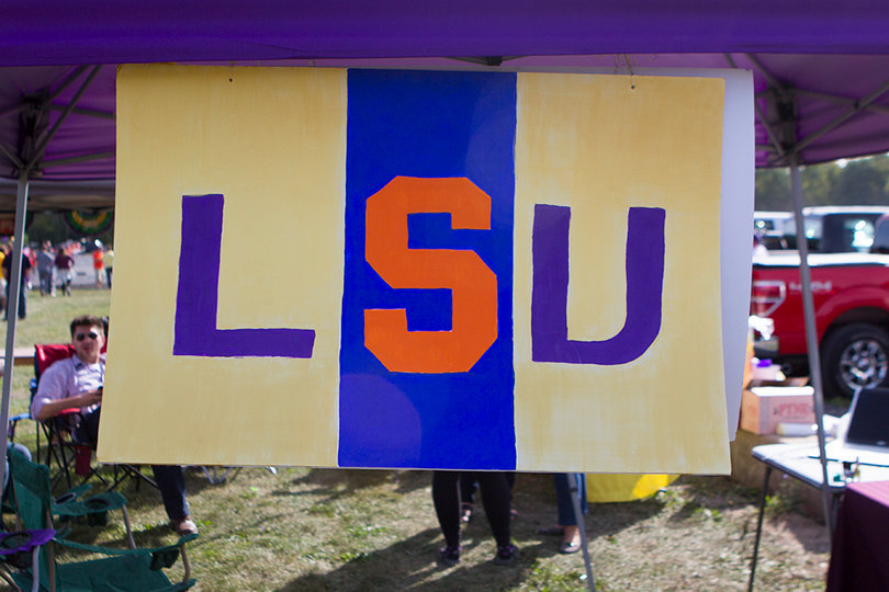 A Syracuse fan hangs an LSU sign with the Orange's block "S" in the middle.