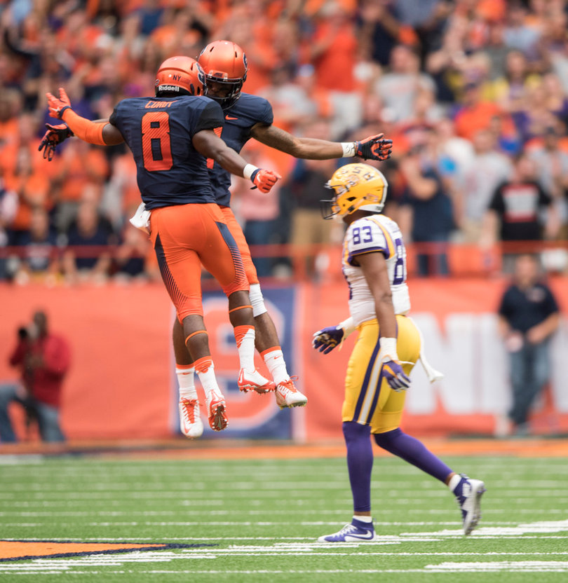 Cordy celebrates a defensive stop with a teammate as LSU wide receiver Travin Dural walks back toward the sideline.