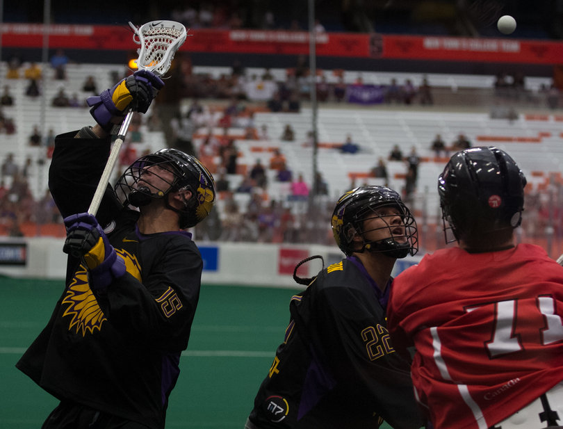 Iroquois defender Tyler Garrison (15) and forward Jerome Haina Thompson (22) vie with Canadian forward Curtis Dickson (71) for the ball. 