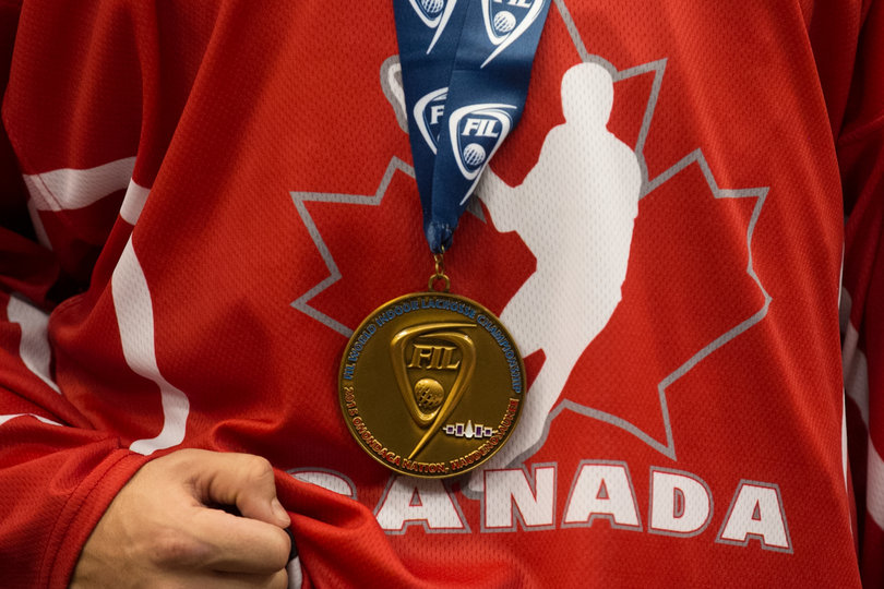 A gold medal hangs on a Canadian player's neck during the postgame celebration. 