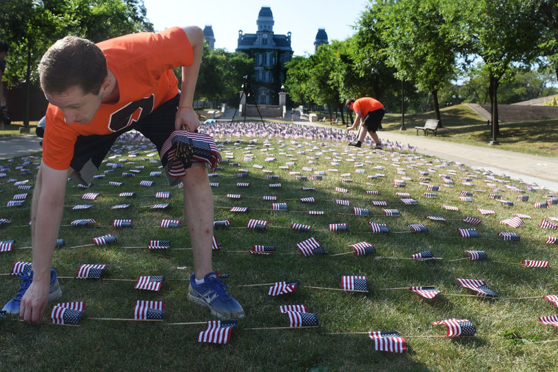 Chris Pulliam, a junior in the College of Arts and Sciences, places U.S. flags on an infield near the Schine Student Center in remembrance of 9/11.  Pulliam and four other students spent several hours placing the flags to honor those who perished.