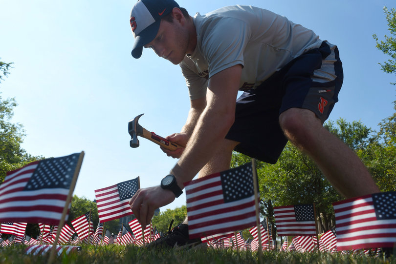 Wyatt Suling, a junior in the College of Arts and Sciences, hammers U.S. flags into the ground in remembrance of 9/11. Suling, a member of the College Republican National Committee, helped lead this effort to honor victims of the attacks.