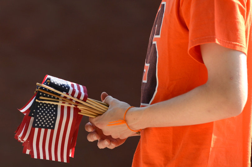 Chris Pulliam, a junior in the College of Arts and Sciences, holds a bundle of U.S. flags as he gets ready to place them on an infield at SU. Hundreds of U.S. flags were placed by Pulliam and four other students to honor and remember those who lost their lives.