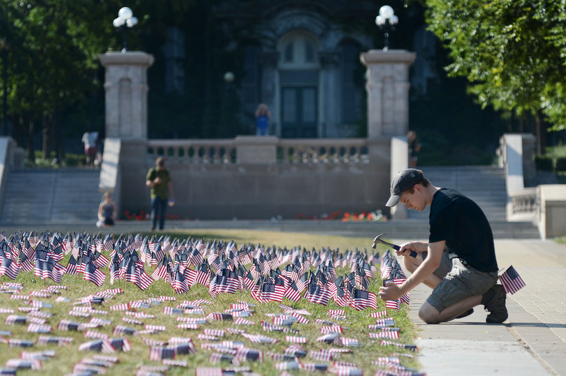 Adam Offutt, a sophomore, hammers U.S. flags into the ground on an infield in remembrance of 9/11. Offutt and four other students spent several hours placing the flags to honor those who perished. 