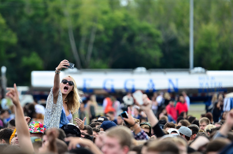Emily Challon, a sophomore advertising major, takes a selfie as she sits on someone's shoulders. 