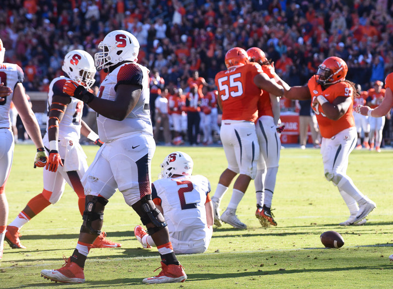 The Cavalier defense celebrates as Eric Dungey sits on the grass at Scott Field. 