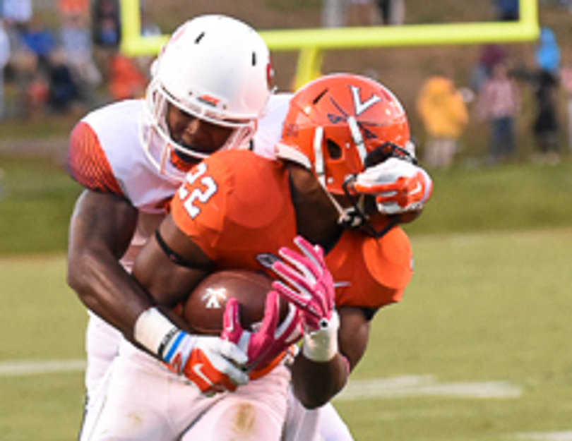 UVA running back Daniel Hamm's facemask is yanked by an SU defender. 