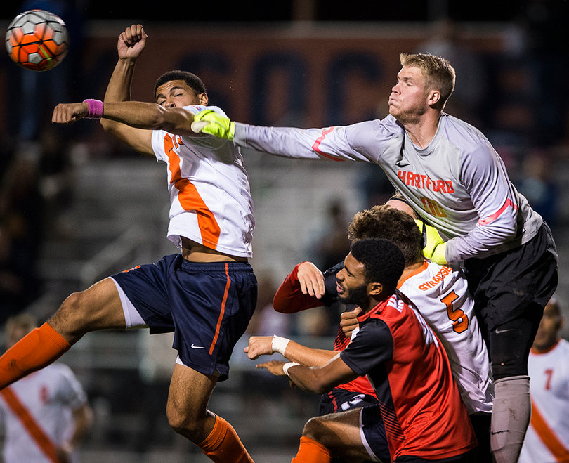 Hartford goalie David MacKinnon attempts to punch the ball out of the air.