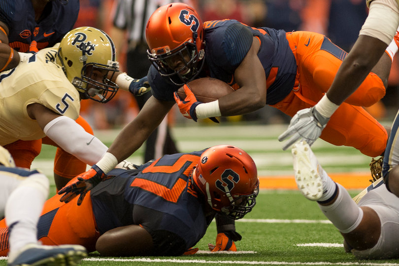 Syracuse running back Jordan Fredericks dives over lineman Omari Palmer (57). 