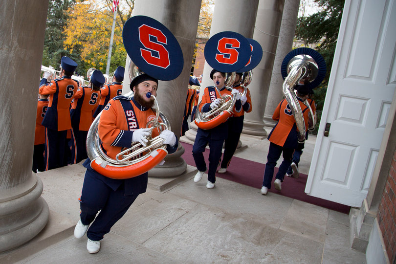 Members of the SU Marching Band Sousaphone section run around the steps of Hendricks Chapel. 