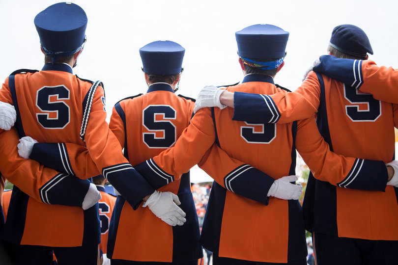 The SU Marching Band stands arm-in-arm on the steps of Hendricks Chapel while the alma mater plays. 