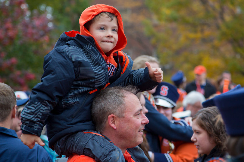 Sully Collette, 6, dances on the shoulders of his father, Tim Collette, as the SU Marching Band plays on the Quad. 