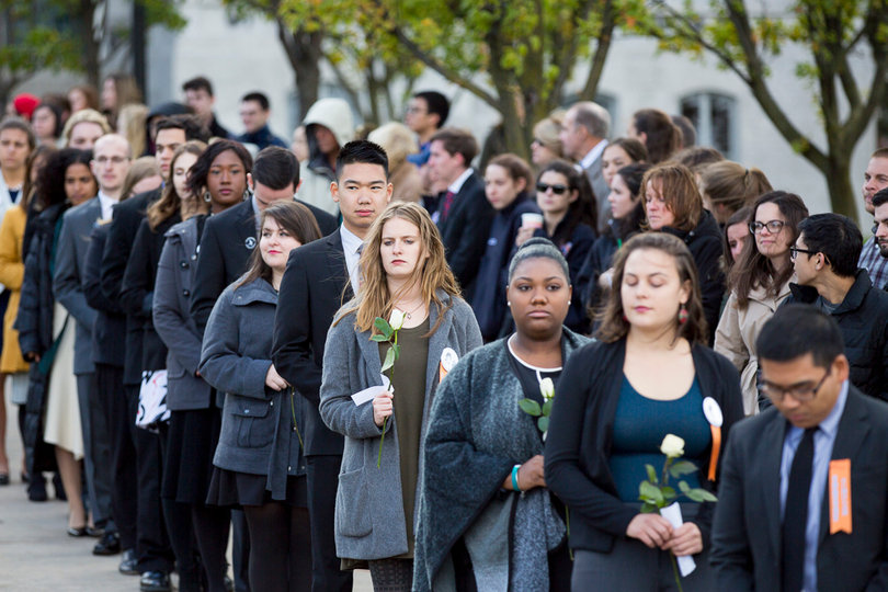 Remembrance Scholars stood on the sidewalks on both sides of the Remembrance Wall as they prepared to place their roses on the wall.