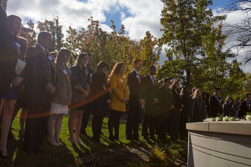 Remembrance Scholars stand around the Remembrance Wall during the Rose Laying Ceremony Friday afternoon.