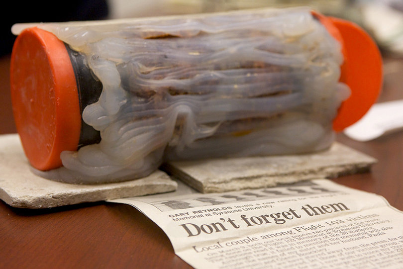 2012: Ed Galvin, director of the Syracuse University Archives, displays a time capsule discovered during the renovation of the Remembrance Wall. The capsule was placed in the wall during its construction in 1990, unbeknownst to university officials. 
