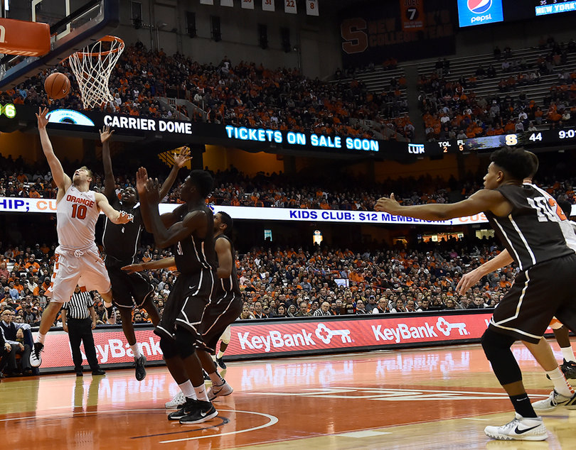 Syracuse's Trevor Cooney (10) weaves through multiple Lehigh players to toss a layup toward the basket.