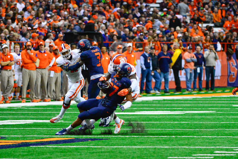 George Morris (27) falls to the turf while Ervin Philips (3) blocks a Clemson defender.